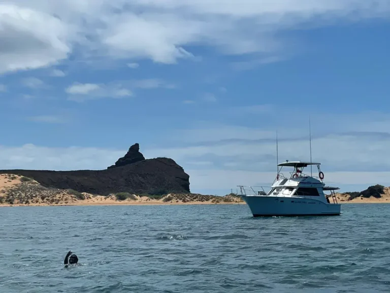 Yate turístico navegando frente a un islote en Galápagos
