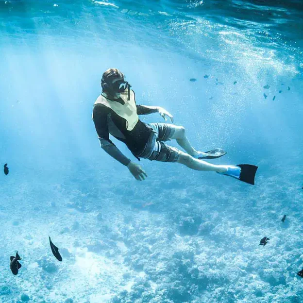 Tourist freediving in blue waters near Tortuga Island, Galapagos
