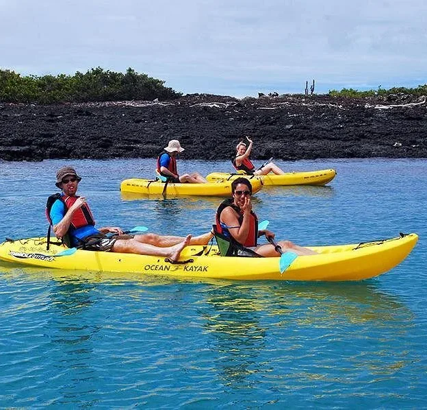 Group of kayakers sailing near rocky islets in the Galapagos