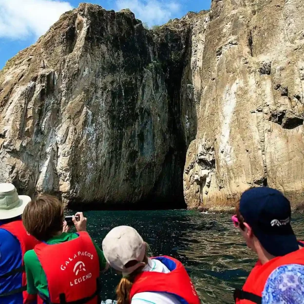 Turistas en lancha observando de cerca las paredes verticales del León Dormido