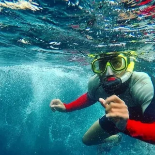 Turistas practicando snorkel con peces tropicales en León Dormido