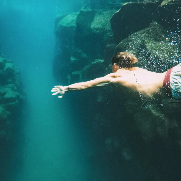 Tourist swimming in crystal-clear waters near León Dormido