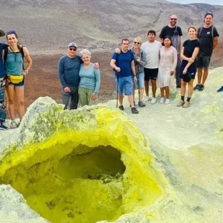 Turistas explorando las formaciones volcánicas amarillas de las Minas de Azufre