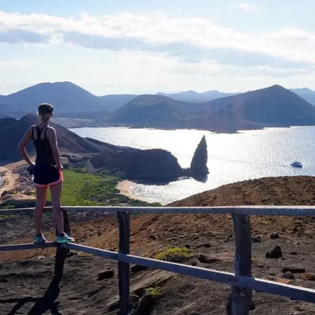 Turista disfrutando del atardecer en el mirador de Isla Bartolomé, Galápagos