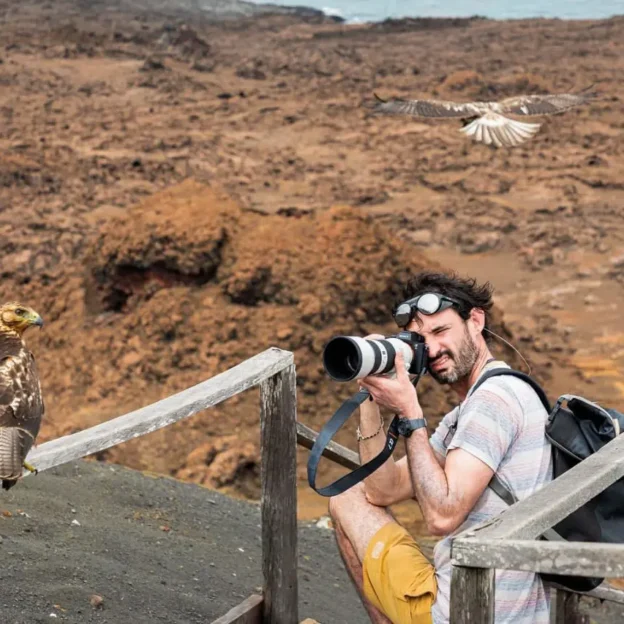 Turista tomando fotos del paisaje volcánico desde el mirador de Bartolomé, Galápagos